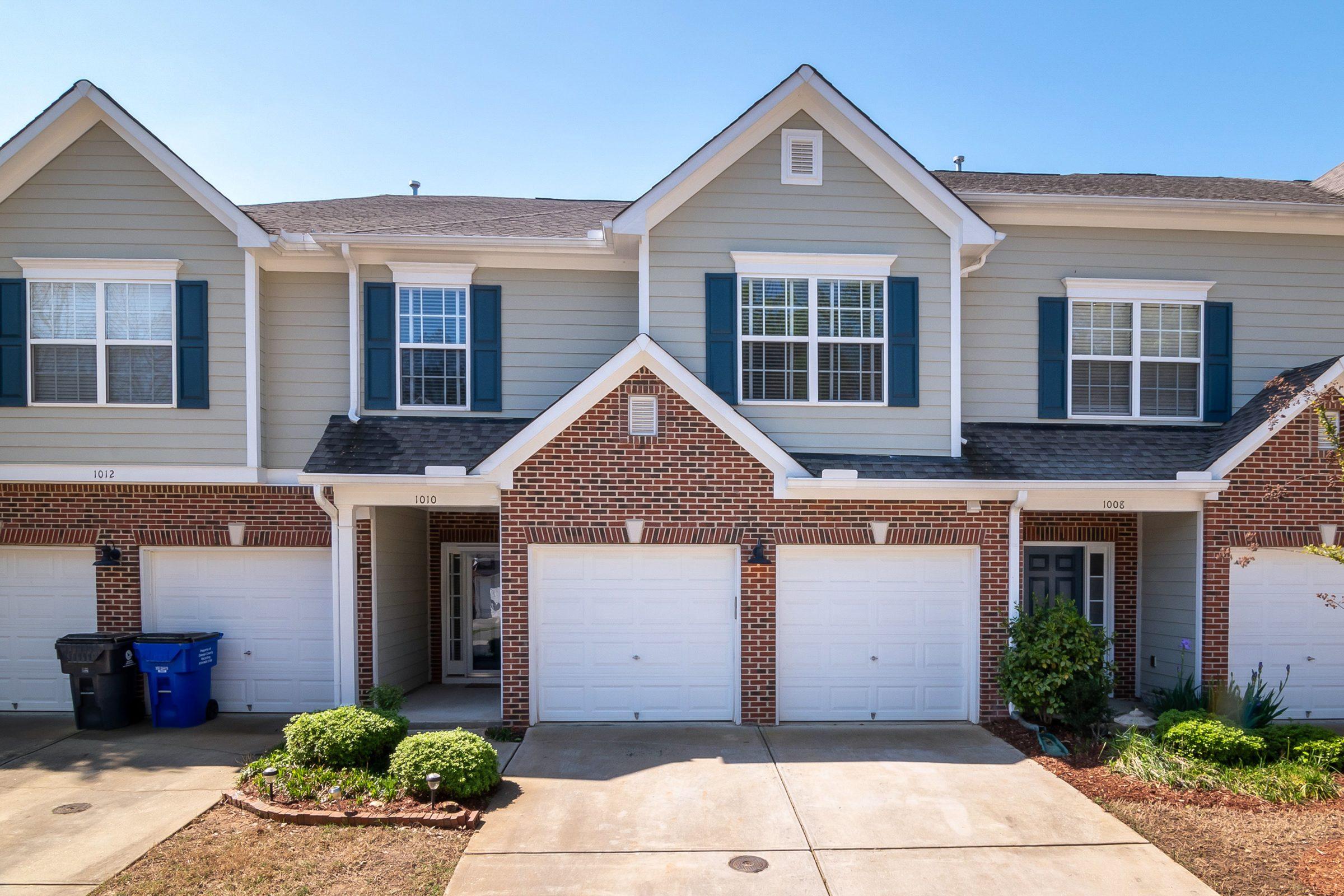 Row of brick and siding townhomes with garages in a planned community